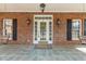 Inviting front porch features a decorative door, sconces, and a swing for relaxing at 6709 Windchase Dr, Rocky Mount, NC 27803