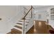 Elegant staircase with wooden treads and white risers leads to the bright living area at 6709 Windchase Dr, Rocky Mount, NC 27803