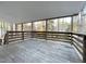 Spacious covered back deck with wood flooring and wooden railing overlooking mature trees at 7780 Brookdale Dr, Raleigh, NC 27616