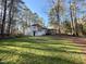 Back exterior of a two-story home with a large backyard, mature trees and landscaping at 7780 Brookdale Dr, Raleigh, NC 27616