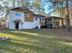 Two-story home with a white brick exterior, wood accents, a deck and an expansive backyard at 7780 Brookdale Dr, Raleigh, NC 27616