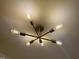 Close-up of a modern gold chandelier with Edison-style lightbulbs at 7780 Brookdale Dr, Raleigh, NC 27616