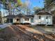 Charming brick home with a teal door and a covered carport for convenient parking at 7780 Brookdale Dr, Raleigh, NC 27616