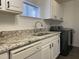 Kitchen area featuring granite counters, stainless sink, and modern appliances and fixtures at 7780 Brookdale Dr, Raleigh, NC 27616