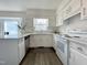 Well-lit kitchen boasts white cabinets, granite countertops, and stainless steel dishwasher at 7780 Brookdale Dr, Raleigh, NC 27616