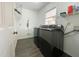 Well-lit laundry room with modern washer/dryer, shelving, and gray wood-look flooring at 7780 Brookdale Dr, Raleigh, NC 27616