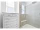 Modern bathroom features a glass-enclosed shower with rainfall showerhead and built-in shelving adjacent to a linen cabinet at 8401 Zinc Autumn Path Path, Raleigh, NC 27615