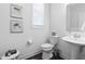 Clean half-bathroom with a pedestal sink, toilet, and decorative accents, offering a fresh and functional space at 8401 Zinc Autumn Path Path, Raleigh, NC 27615