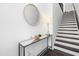 Modern entryway with a round mirror, stylish console table, and staircase leading to the upper level at 8401 Zinc Autumn Path Path, Raleigh, NC 27615
