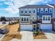Beautiful townhome showcasing a two-car garage, manicured landscaping, and a mix of stone and siding at 8401 Zinc Autumn Path Path, Raleigh, NC 27615