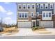 Beautiful townhome exterior featuring a stone and siding facade, two-car garage, and well-maintained landscaping at 8401 Zinc Autumn Path Path, Raleigh, NC 27615