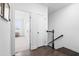 Hallway with hardwood floors, white walls, staircase, and an open doorway, leading to other rooms at 8401 Zinc Autumn Path Path, Raleigh, NC 27615