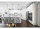 Modern kitchen with white cabinets, stainless steel appliances, center island with barstool seating, and hardwood floors at 8401 Zinc Autumn Path Path, Raleigh, NC 27615