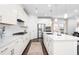 Modern kitchen with white cabinets, stainless steel appliances, and a large island with counter seating at 8401 Zinc Autumn Path Path, Raleigh, NC 27615