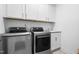 Well-equipped laundry room features new stainless steel washer, dryer, white shaker cabinets, and a utility sink at 8401 Zinc Autumn Path Path, Raleigh, NC 27615