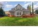 Spacious backyard featuring a large wooden deck, lush green lawn and a classic home exterior with large windows at 8608 Davishire Dr, Raleigh, NC 27615