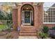 Charming front entrance with brick steps, decorative wreath on a blue door, and brick archway at 8608 Davishire Dr, Raleigh, NC 27615