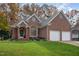 Beautiful brick home featuring an attached two-car garage and a manicured lawn with mature landscaping at 8608 Davishire Dr, Raleigh, NC 27615