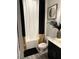 Neat bathroom featuring black, white, and gold accents, plus a shower/tub combo at 94 Aylebury Rdg, Zebulon, NC 27597