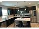 Modern kitchen featuring black cabinets, stainless steel appliances, and a quartz countertop island at 94 Aylebury Rdg, Zebulon, NC 27597