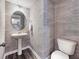 Stylish powder room with unique wallpaper, a pedestal sink, and a modern toilet at 1008 Sora Way, Durham, NC 27703