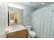 Well-lit bathroom featuring a marbled countertop and a blue patterned shower curtain at 10115 Mizner Ln, Raleigh, NC 27617