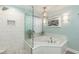 Serene bathroom showcasing a tiled shower, soaking tub, and decorative lighting at 10115 Mizner Ln, Raleigh, NC 27617