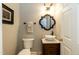 Powder room featuring a modern sink, elegant mirror, decorative wall art and neutral color palette at 10115 Mizner Ln, Raleigh, NC 27617