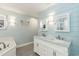 Elegant bathroom featuring dual sinks, blue shiplap walls, and a soaking tub at 10115 Mizner Ln, Raleigh, NC 27617