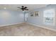 Light-filled bedroom with plush carpeting, ceiling fan, fresh blue walls and large windows at 10115 Mizner Ln, Raleigh, NC 27617