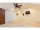 Carpeted bonus room with ceiling fan, TV, and ample space for storage and entertainment at 10115 Mizner Ln, Raleigh, NC 27617