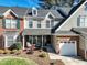 Charming two-story home with manicured front yard and inviting front porch with chairs and decorative landscaping at 10115 Mizner Ln, Raleigh, NC 27617