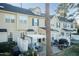 Back exterior view of townhomes with well-maintained patios and green space at 10115 Mizner Ln, Raleigh, NC 27617