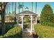 Charming gazebo with seating, nestled among lush landscaping and mature trees at 10115 Mizner Ln, Raleigh, NC 27617