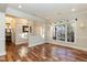 Open living room featuring hardwood floors, large windows providing natural light and views into the foyer at 10115 Mizner Ln, Raleigh, NC 27617