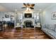 Cozy living room with fireplace, ceiling fan, hardwood floors, and natural light from shuttered windows at 10115 Mizner Ln, Raleigh, NC 27617