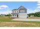 New construction two-story home featuring a wide driveway, attached garage, and manicured lawn at 108 Grove Township Way, Angier, NC 27501