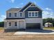 Charming two-story home with blue and gray siding, classic architectural details, and an attached two-car garage at 108 Grove Township Way, Angier, NC 27501