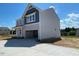 Side view of the home displaying gray siding and showing the concrete driveway leading to the two-car garage at 108 Grove Township Way, Angier, NC 27501