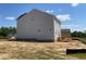 Side view of a new gray two-story home with unfinished landscaping at 108 Grove Township Way, Angier, NC 27501