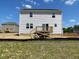 Rear view of a new two-story white home with a wooden deck at 108 Grove Township Way, Angier, NC 27501