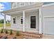 Inviting front porch with white columns, brick accents, and a stylish black front door at 108 Grove Township Way, Angier, NC 27501