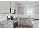 Modern kitchen featuring granite countertops, stainless steel appliances, and subway tile backsplash at 108 Grove Township Way, Angier, NC 27501