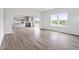 Spacious open-concept living area featuring wood-look floors, a modern kitchen, and large windows at 108 Grove Township Way, Angier, NC 27501