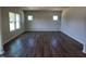 Living room with wood flooring and multiple windows allowing natural light at 108 Grove Township Way, Angier, NC 27501
