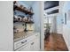 Chic bar area with granite countertop, white cabinets, wooden shelves, and an open view to dining room at 1137 Fanning Dr, Wake Forest, NC 27587