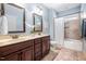 Stylish bathroom featuring double sinks, a large mirror, and a tiled shower and tub at 1137 Fanning Dr, Wake Forest, NC 27587