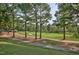 Scenic view of a well-maintained golf course with lush green fairways, mature trees, and a paved walking path at 1137 Fanning Dr, Wake Forest, NC 27587