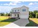 Two-story home featuring an attached garage, well-manicured lawn, and charming front porch at 119 Grove Township Way, Angier, NC 27501