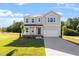 Charming two-story home with a well-manicured lawn and a classic facade under a bright blue sky at 119 Grove Township Way, Angier, NC 27501